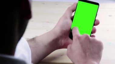 ahşap masa görünümü, yeşil ekran, smartphone ile yaşam tarzı iletişim arkasında chroma anahtar ile bir akıllı telefon kullanarak adam ele