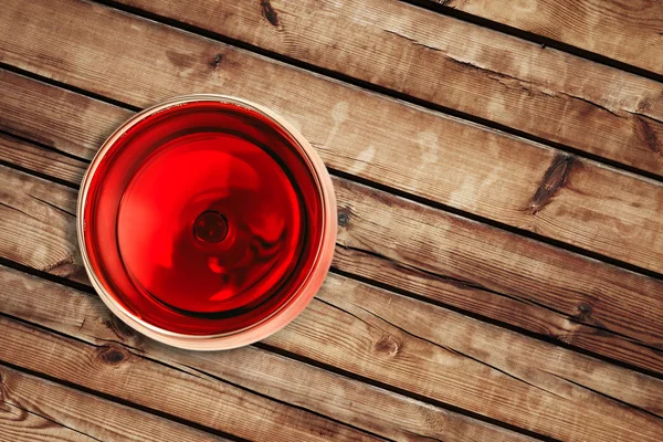 Arriba de la vista del vino tinto en la copa aislada sobre fondo de madera — Foto de Stock