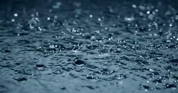 Cámara lenta fuertes gotas de agua de lluvia en la calle de superficie — Vídeo de stock