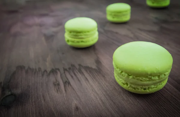 Pastel verde macaron sobre fondo de madera, maccarone postre dulce — Foto de Stock