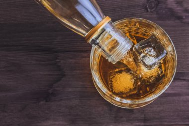 ahşap masa arka plan, buz üzerinde odak üzerinde cam buz küpleri ile dökme viski barmen görünümünün üst