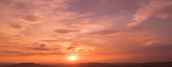 Sunset scen med solen faller och ray ljus, molnen i bakgrunden, varmt färgglada himlen — Stockfoto