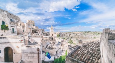 panoramik tipik taşlar (Sassi di Matera) ve kilise Matera mavi gökyüzü altında 