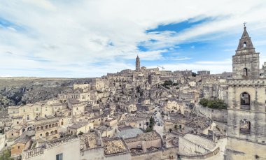 panoramik tipik taşlar (Sassi di Matera) ve kilise Matera mavi gökyüzü altında
