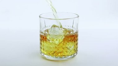 Beyaz arka plan üzerinde bardakta viski dökme barmen