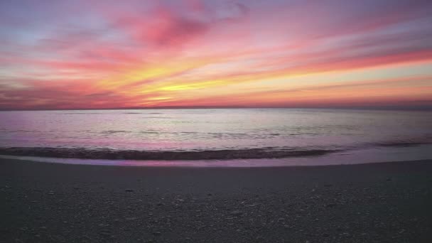 Cena do pôr do sol com mar calma e sol cair atrás das nuvens no fundo — Vídeo de Stock