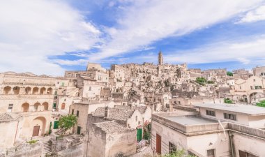 panoramik tipik taşlar (Sassi di Matera) ve kilise Matera mavi gökyüzü altında