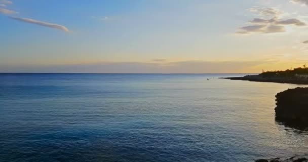 Famosa, bela praia ao pôr do sol com mar calmo, no verão muito popular, costa arenosa tem uma vista fantástica da ilha de ibiza. — Vídeo de Stock