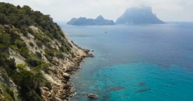 Ünlü, güzel plaj, gün ışığında sakin deniz, yazın çok popüler, kumlu sahil harika bir İbiza adası manzarası var..
