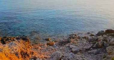Tropikal Karayip plajı manzarası altın rengi kum ve kayalarla yeşil ve mavi deniz, tatil, gün batımında sakin deniz hareketleri