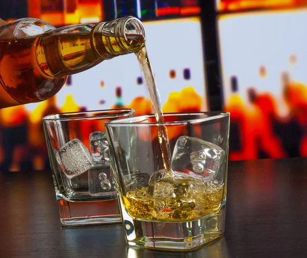 Бармен наливает виски на барный стол — стоковое фото