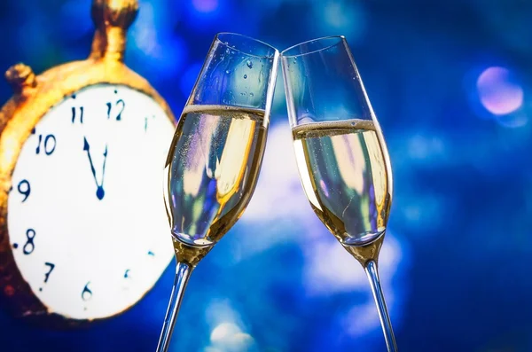 Nowy rok lub Boże Narodzenie na północy z flety szampana zrobić bokeh okrzyki niebieski i zegar — Zdjęcie stockowe