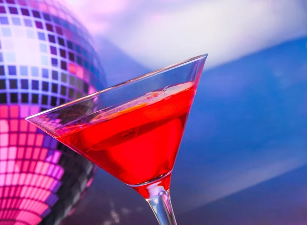 Red cocktail with sparkling disco ball background with space for text — Stock Photo, Image