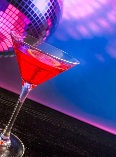 Червоний коктейль з лимонним шматочком та ігристим диско-кульковим фоном з місцем для тексту — стокове фото