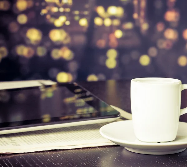 Xícara de café na frente do tablet digital pc perto da janela, estilo vintage — Fotografia de Stock