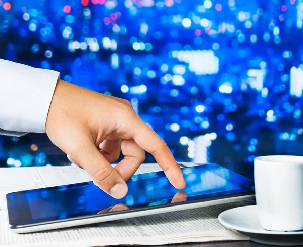 Zakenman touch digitale tablet op zakelijke krant in de buurt van venster — Stockfoto