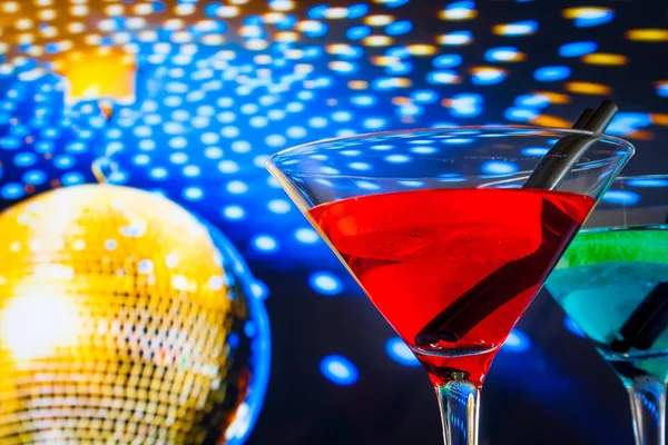 Red cocktail with golden sparkling disco ball background with space for text — Stock Photo, Image