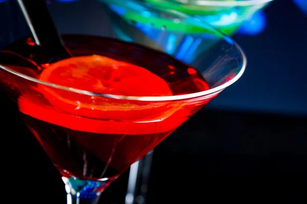Top of view of red cocktail with blue light disco background with space for text — Stock Photo, Image