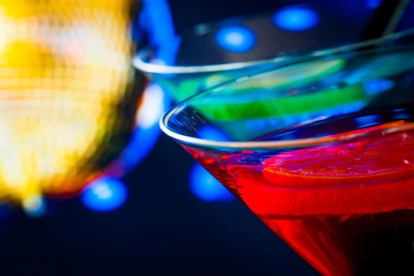 Detail of red cocktail with golden sparkling disco ball background with space for text — Stock Photo, Image