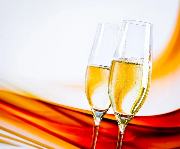 Una coppia di flauti champagne con bollicine dorate su fondo chiaro sfocato — Foto Stock