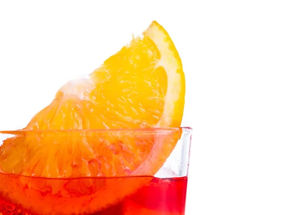 Rebanada naranja en la parte superior del cóctel rojo con cubitos de hielo sobre fondo blanco —  Fotos de Stock