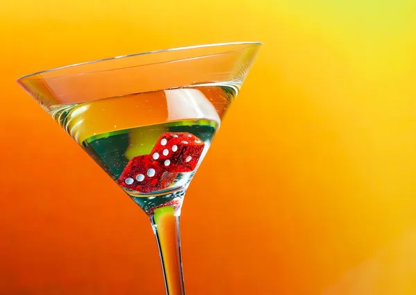 Dadi rossi nel bicchiere da cocktail su pendenza dorata — Foto Stock