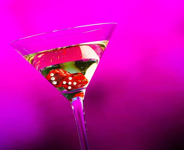 Dés rouges dans le verre à cocktail sur fond violet — Photo