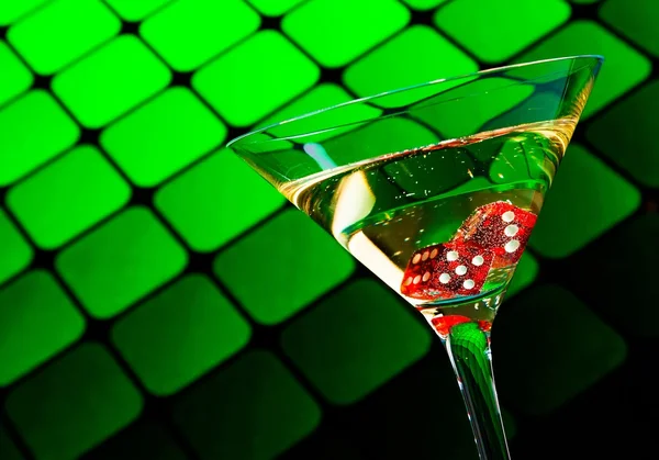 Red dice in the cocktail glass on blur green — Stock Photo, Image