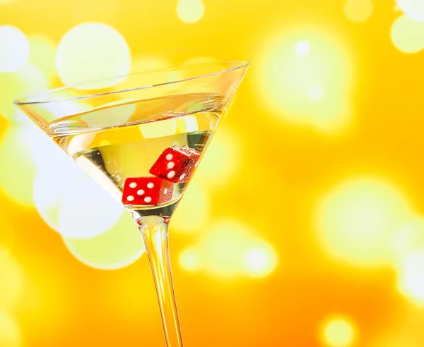 Red dice in the cocktail glass on golden bokeh — Stock Photo, Image