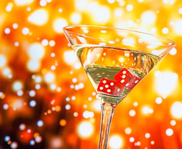 Rote Würfel im Cocktailglas auf goldenem Bokeh — Stockfoto