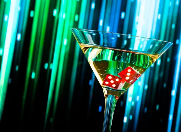 Red dice in the cocktail glass on colorful gradient — Stock Photo, Image