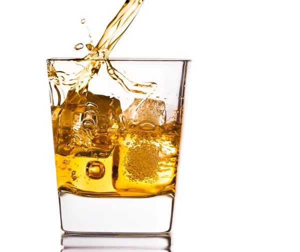 Pouring scotch whiskey in glass with ice cubes on white — Stock Photo, Image