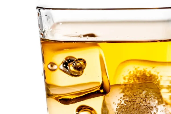 Detalj av skotsk whisky i glas med isbitar på vit — Stockfoto