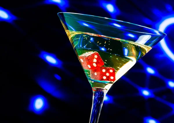 Червоні кубики в коктейльному келиху на концепції казино синього світла — стокове фото
