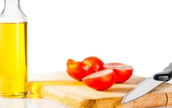 Tomates cerises fraîches et mûres sur une vieille planche à découper. Bouteille d'huile d'olive en arrière-plan — Photo