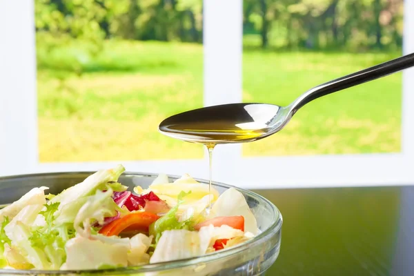 Spoon with olive oil on italian fresh salad — Stock Photo, Image