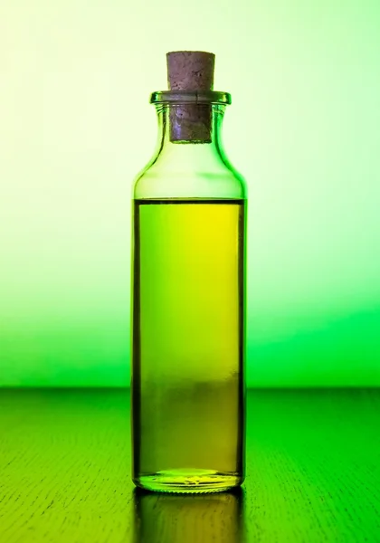 Olive oil bottle on green light tint — Stock Photo, Image