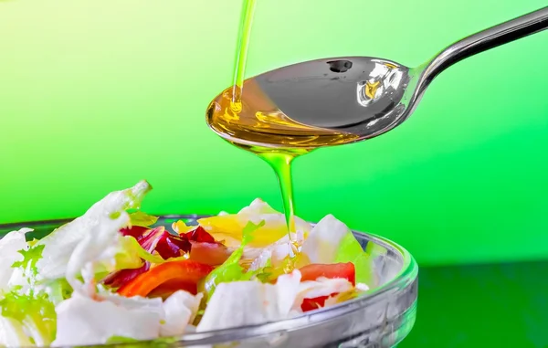 Spoon with olive oil on italian fresh salad — Stock Photo, Image
