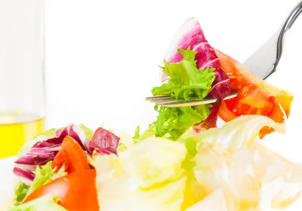 Beyaz arka planda zeytinyağı şişesi ile İtalyan taze salata çatalı Close-Up — Stok fotoğraf