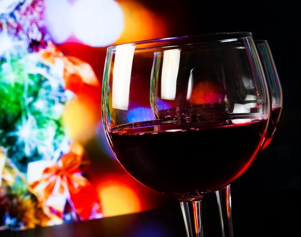 Deux verres à vin rouge sur table en bois sur fond clair de sapin de Noël — Photo