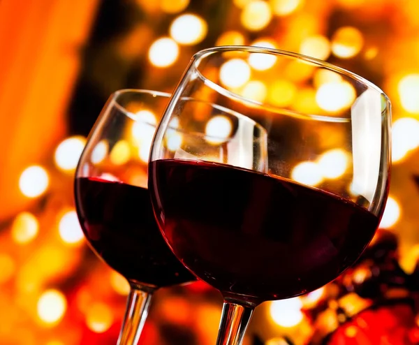 Two red wine glasses against tree of bokeh lights background — Stock Photo, Image