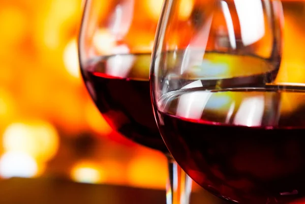 Iki kırmızı şarap gözlük renkli odaklanmamış ışıklar arka plan detay — Stok fotoğraf