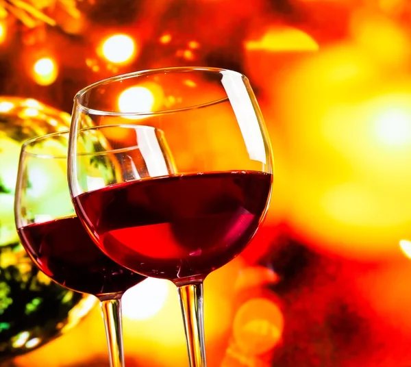 Red wine glasses against colorful unfocused lights background — Stock Photo, Image