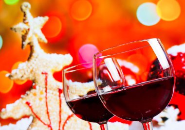 Noel ağacı arka plan karşı iki kırmızı şarap bardakları