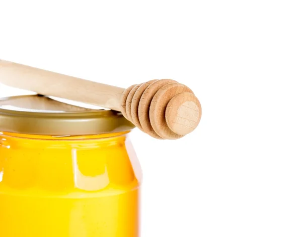 Närbild av honung burk på vit bakgrund med trä honung strömstare — Stockfoto