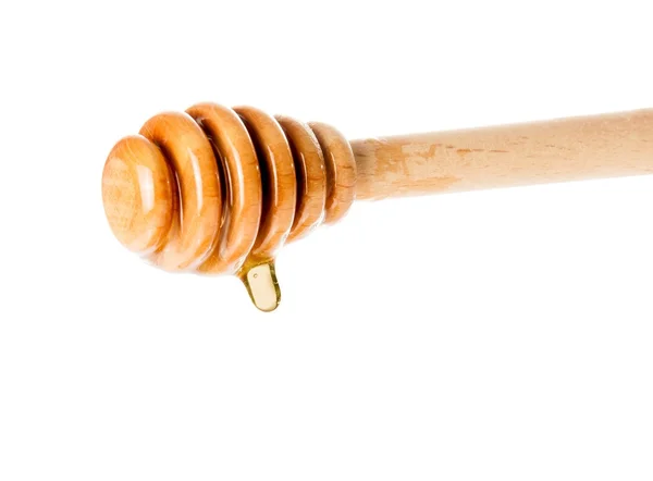 Wooden honey dipper with drop honey white background — Stock Photo, Image