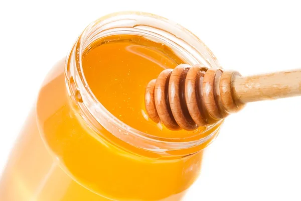 Honey jar på vit bakgrund med trä honung skopa på toppen — Stockfoto