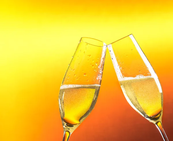 Two flutes of champagne with golden bubbles and space for text — Stock Photo, Image