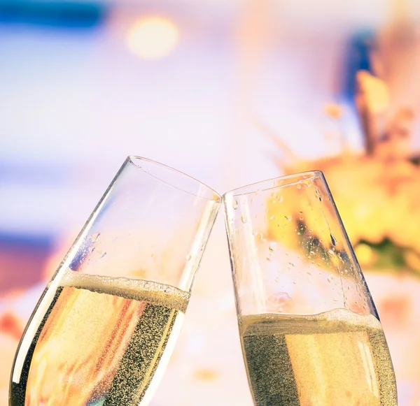 Champagne flöjter med gyllene bubblor på blommor bakgrund, bröllop och alla hjärtans dag koncept — Stockfoto