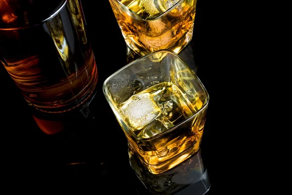 Top of view of whiskey with ice in glass on black background — Stock Photo, Image